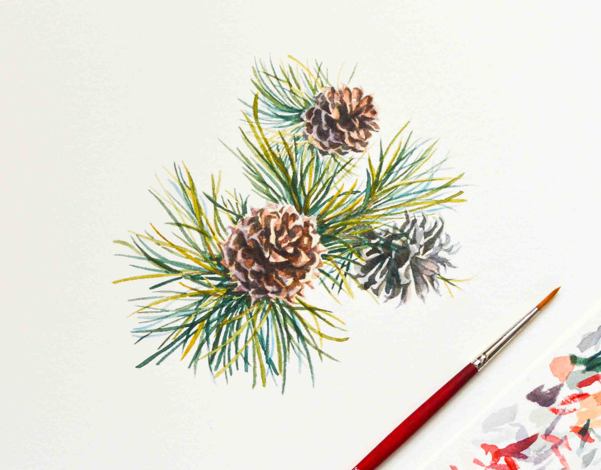 A watercolor painting of three pinecones nestled among green and yellow pine needles on textured white paper, with a red-handled paintbrush in the lower right corner.