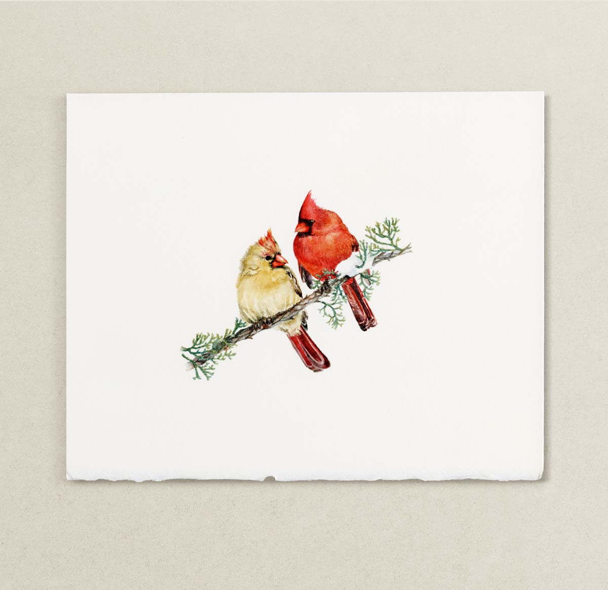 A watercolor painting featuring a watercolor illustration of two cardinals perched on a small branch, displayed against a neutral textured beige background.