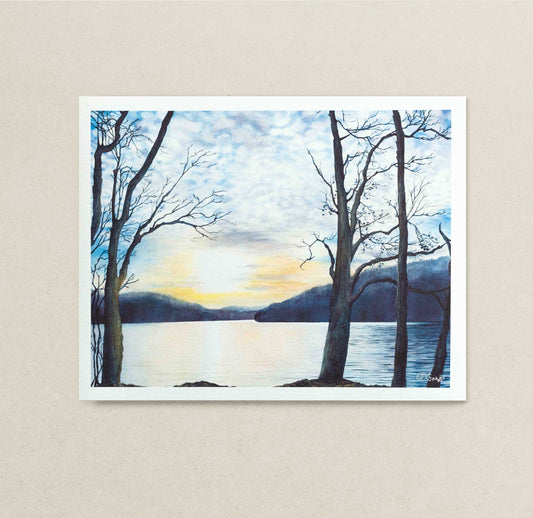 Art print of a sunset over Cheat Lake, WV with bare trees on a beige wall.