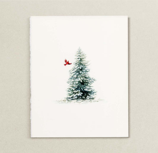 A vertical watercolor painting featuring a snow-dusted evergreen tree with a small red cardinal perched on its side, set against a clean off-white background and displayed on a textured light beige wall.
