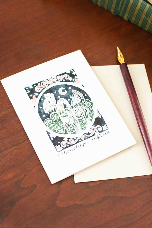 Greeting card with decorative Ghost Flower design on a wooden surface with a pen.