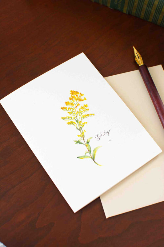 Greeting card with yellow Goldenrod design on a wooden surface