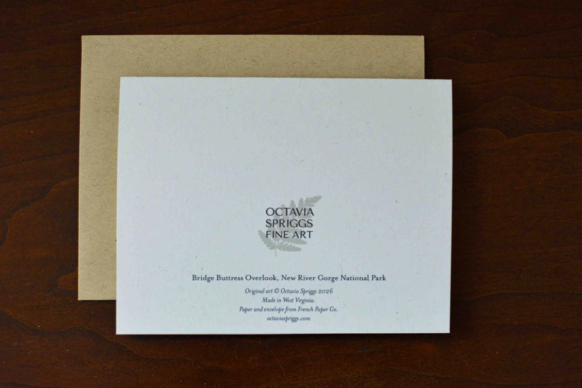White backside of a notecard reading "Bridge Buttress Overlook, New River Gorge National Park" with the Octavia Spriggs Fine Art Logo. 